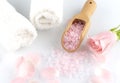 Rose petals with pink salt on wooden spoon and white towels on white background Royalty Free Stock Photo