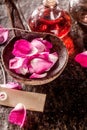Rose Petals, Spa Oils and Tag on Rustic Table Royalty Free Stock Photo