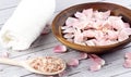 Rose petals on a wooden bowl with pink salt and white towel on wooden background Royalty Free Stock Photo