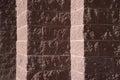 rose and pink colored stone block wall in shadow and light creating light colored stripes Royalty Free Stock Photo