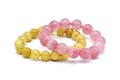 Rose quartz bracelet and golden rutilated quartz bracelet crystal gemstone on white background.