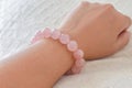 Rose quartz bracelet on woman wrist. Royalty Free Stock Photo