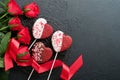 Rose red flowers, brownie cookies and chocolate candy on heart shaped, gift box with wine on black background. Valentines day, Mot Royalty Free Stock Photo