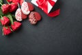 Rose red flowers, brownie cookies and chocolate candy on heart shaped, gift box with wine on black background. Valentines day, Mot Royalty Free Stock Photo