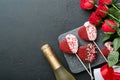 Rose red flowers, brownie cookies and chocolate candy on heart shaped, gift box with wine on black background. Valentines day, Mot Royalty Free Stock Photo