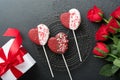 Rose red flowers, brownie cookies and chocolate candy on heart shaped, gift box with wine on black background. Valentines day, Mot Royalty Free Stock Photo