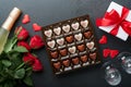 Rose red flowers brownie cookies and chocolate candy on heart shaped, gift box with wine on black background. Valentines day, Moth Royalty Free Stock Photo