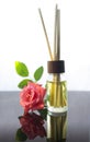 Rose scented oil bottle with wooden sticks on white Royalty Free Stock Photo