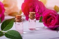 Rose water or essential oil in glass bottles with flowers on wooden table Royalty Free Stock Photo