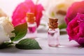 Rose water or essential oil in glass bottles with flowers on wooden table Royalty Free Stock Photo