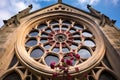 a rose window atop a gothic revival stone entrance