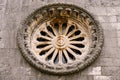 Rose window with ornaments and patterns on the dark stone wall of the church Royalty Free Stock Photo