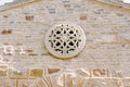 Rose window with ornaments and patterns on the stone wall of the church Royalty Free Stock Photo