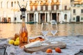 Rose wine, fruits and snacks on the wooden pier during picturesque picnic on the wooden dock