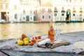 Rose wine, fruits and snacks on the wooden pier during picturesque picnic on the wooden dock