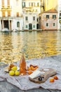 Rose wine, fruits and snacks on the wooden pier during picturesque picnic on the wooden dock