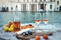 Rose wine, fruits and snacks on the wooden pier during picturesque picnic on the wooden dock