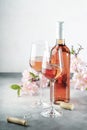 Rose wine glass and bottle on the gray table and pink flowers. Rosado, rosato or blush wine tasting Royalty Free Stock Photo