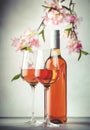 Rose wine glass and bottle on the gray table and pink flowers. Rosado, rosato or blush wine tasting Royalty Free Stock Photo