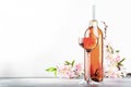 Rose wine glass and bottle on the gray table and pink flowers. Rosado, rosato or blush wine tasting Royalty Free Stock Photo