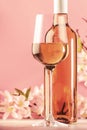 Rose wine glass with bottle and pink flowers. Rosado, rosato or blush wine tasting in wineshop, bar concept. Copy Space Royalty Free Stock Photo