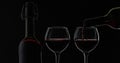 Rose wine. Red wine pour in wine glass over black background. Silhouette Royalty Free Stock Photo