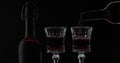 Rose wine. Red wine pour in wine glass over black background. Silhouette Royalty Free Stock Photo