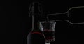 Rose wine. Red wine pour in wine glass over black background. Silhouette Royalty Free Stock Photo