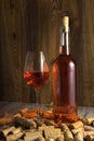 Rose wine in a transparent bottle, glass, cork and a corkscrew