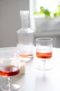 Rose wine in trendy ribbed wineglasses and decanter on white table Royalty Free Stock Photo