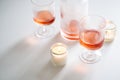 Rose wine in trendy ribbed wineglasses and decanter on white table Royalty Free Stock Photo