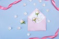 Rosebuds, petals, congratulatory envelope, on a blue background. Concept for a greeting card. Weddings, Valentine`s Day Royalty Free Stock Photo