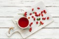 Rosehip glass cup of herbal tea medicinal plants with rosehip fruits on rustic table