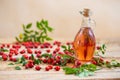 Rosehip oil in glass bottle on wooden table horizontal