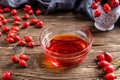 Rosehip seed oil in a bowl with fresh rosehips