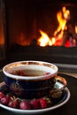 Rosehip tea in front of roaring fire in a fire place Royalty Free Stock Photo