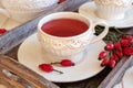 Rosehip tea in white vintage cups with fresh berries