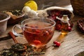 Rosehip tea on wooden background with red fruits