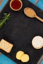 Rosemary, cheese and biscuits with spices on slate board Royalty Free Stock Photo