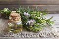 Rosemary essential oil in a glass bottle with fresh green rosemary herb on old wooden table for spa, aromatherapy and bodycare. Royalty Free Stock Photo