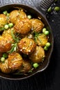 Rosemary and garlic roast potatoes with green peas on a cast iron pan Royalty Free Stock Photo