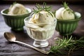rosemary infusion ice cream in a glass cup with fresh rosemary twigs on the side