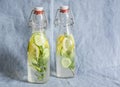 Rosemary, lemon, cucumber lemonade in vintage bottles on a blue background