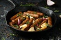 Rosemary and onion vegetarian vegan sausages oven baked in cast iron skillet frying pan