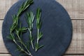 Rosemary plant on black slate board, wooden background. Fresh he Royalty Free Stock Photo