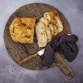 Rosemary and rock salt Focaccia bread on a retro wooden bread board with a knife and napkin