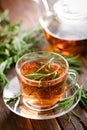 Rosemary tea in glass tea cup on rustic wooden table closeup. Herbal vitamin tea Royalty Free Stock Photo