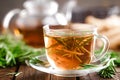 Rosemary tea in glass tea cup on rustic wooden table closeup. Herbal vitamin tea