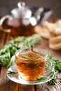 Rosemary tea in glass tea cup on rustic wooden table closeup. Herbal vitamin tea Royalty Free Stock Photo