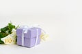 Roses and gift on light background with copy space, selective focus Royalty Free Stock Photo
